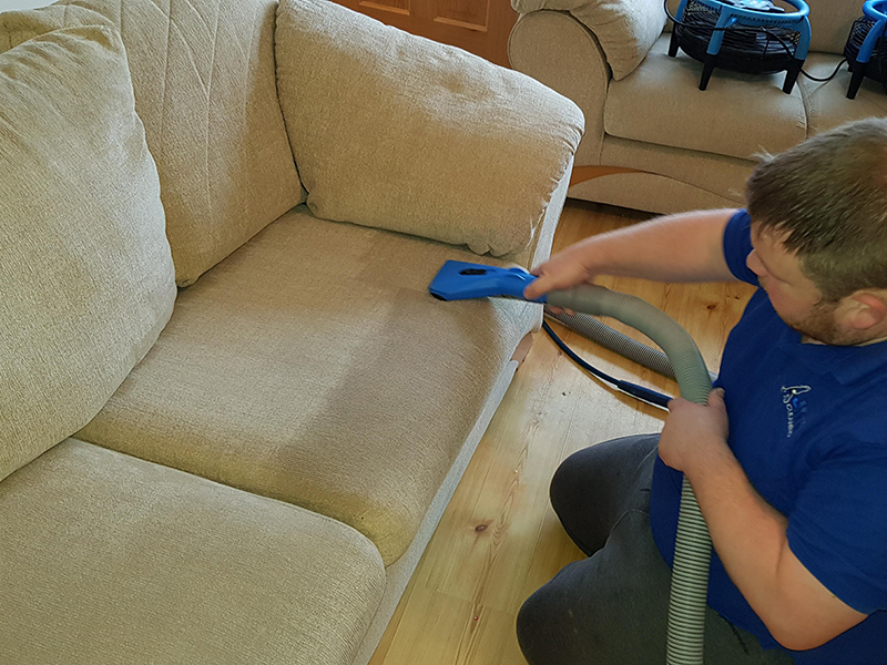 Upholstery cleaning from JR’s own gallery: a technician carefully cleaning a cream sofa